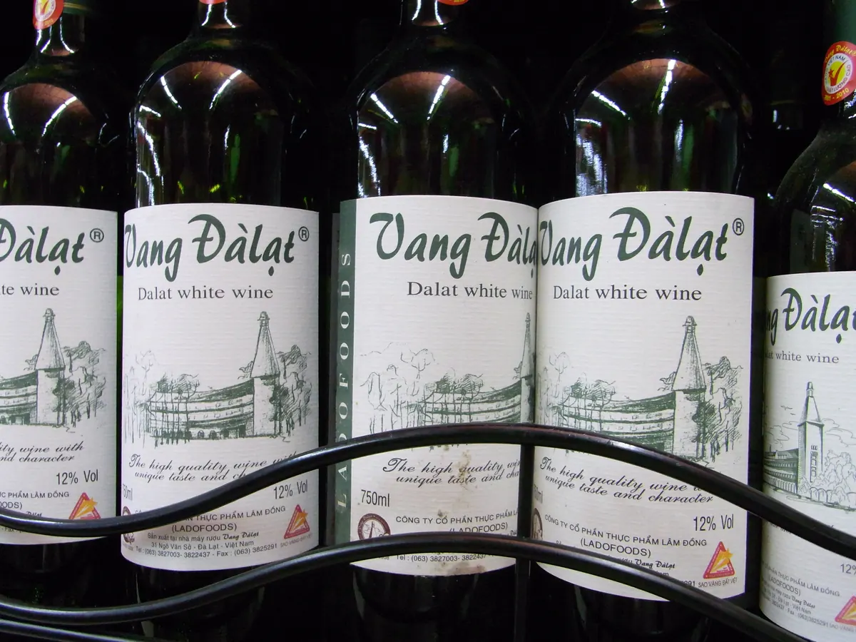 Hàng chai rượu vang trắng nhãn Vang Đà Lạt xếp trên kệ